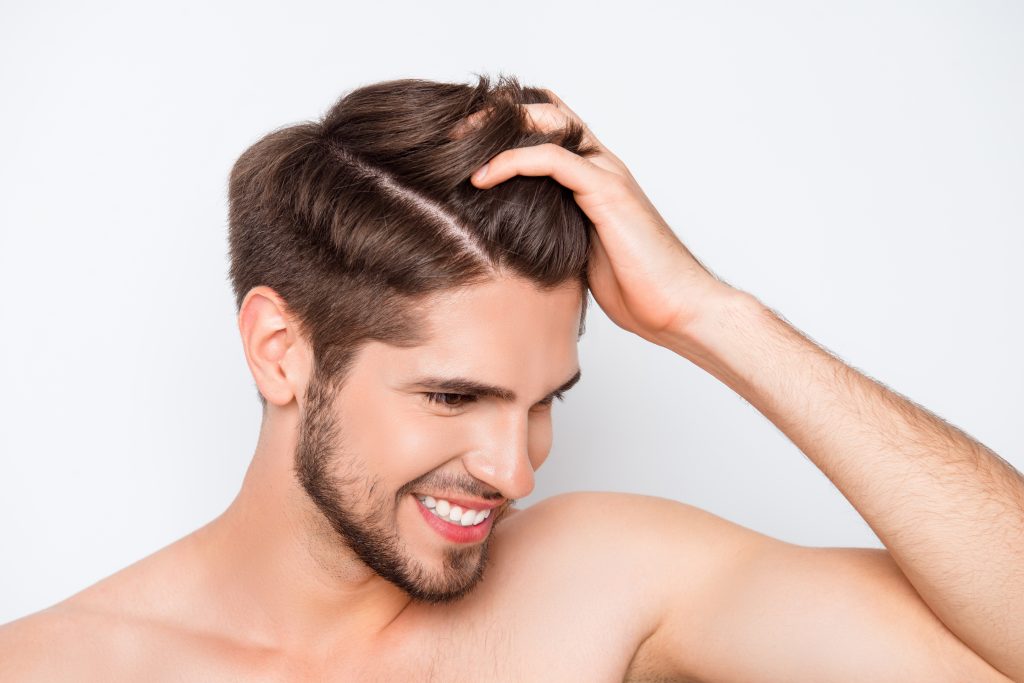 Man holding his hair - FUE hair transplant Singapore